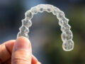 Holding invisalign braces on bokeh background