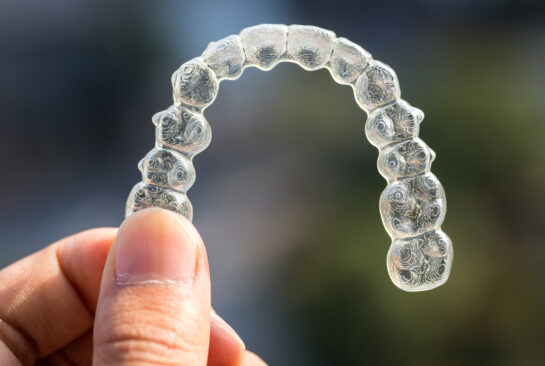 Holding invisalign braces on bokeh background