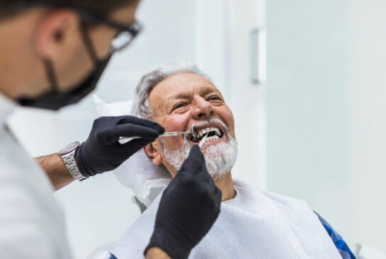 Senior man having dental treatment at dentist's office.